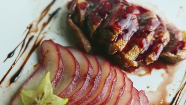 Closeup trendy decorated sliced grilled duck breast rotates on plate — 비디오