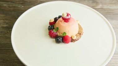 Taze nane, ahududu, yaban mersini ve bize modern restoran tabağında dönüşümlü pembe kremalı tatlıdan uzaklaşın.