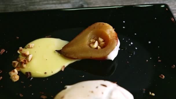 从焦糖化梨子半到薄片饼干蛋糕 用慕斯奶油和巧克力装饰在黑盘上 — 图库视频影像