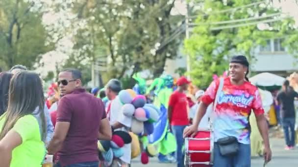 People in colorful costumes walk on dominican city street at carnival annual event — Stock Video
