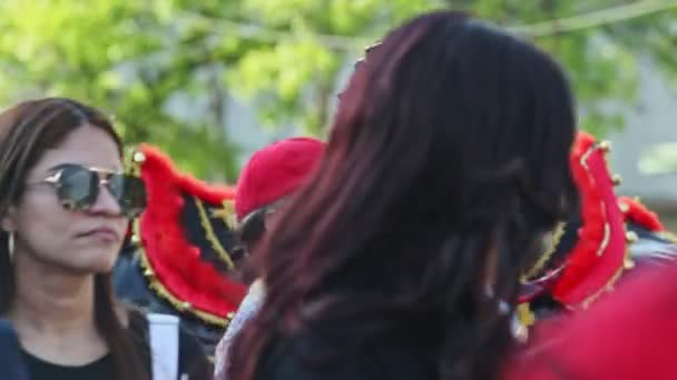 Люди фотографують з костюмованим демоном на доміканській міській вулиці на щорічному карнавалі. — стокове відео