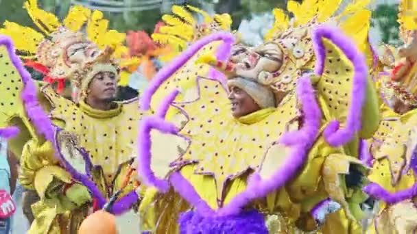 Gente en trajes coloridos caminan en la calle dominicana de la ciudad en el evento anual del carnaval — Vídeos de Stock