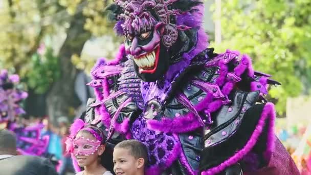 İnsanlar geleneksel karnavalda Dominik Şehri caddesinde kostümlü iblislerle fotoğraf çekiyorlar. — Stok video