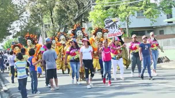 Obywatele w żywych kostiumach maskarady przechodzą ulicą miasta w Dominican Carnival — Wideo stockowe