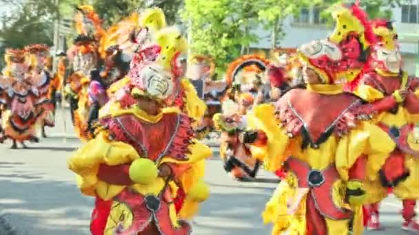 Люди в различных костюмах маскарад прогуливаются по городской улице на доминиканском карнавале — стоковое видео