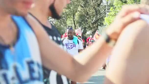 Ludzie w zróżnicowanych strojach karnawałowych spacerują ulicą Dominikany na dorocznej paradzie — Wideo stockowe
