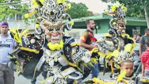 Persona en traje de demonio de miedo baila en la cámara en la calle de la ciudad en el carnaval dominicano — Vídeo de stock