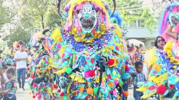 Hombre alto en traje colorífico posan para la foto en la calle de la ciudad en el carnaval dominicano — Vídeos de Stock