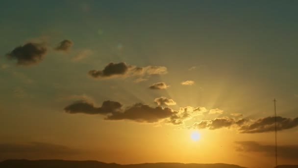 Slow zoom in at golden sunset with rays through dark clouds — Stok video