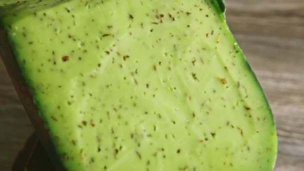 Closeup big piece of organic cheese with herbs spinning around on small plate — Stockvideo