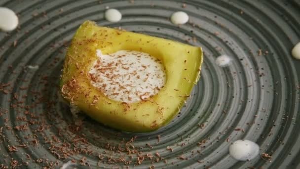 Closeup exquisite decorated creamed avocado dessert rotates on modern plate — Stok video