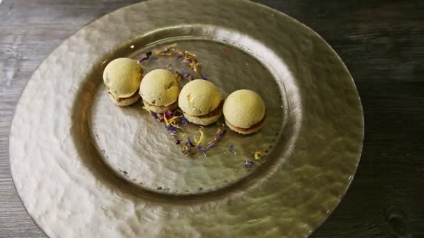 Trendy decorated four spherical sponge biscuits spinning on around plate — Stok video