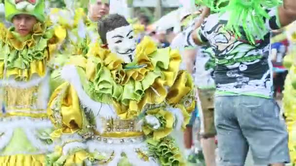 Hombres con trajes de payasos asustadizos corren a cámara en la calle de la ciudad en el carnaval dominicano — Vídeo de stock