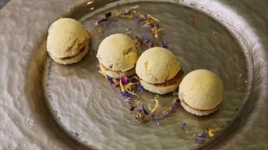 slow zoom out from trendy decorated four spherical sponge biscuits on plate