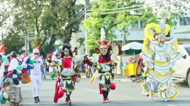 Personas de primer plano en trajes variados de carnaval caminan por la calle de la ciudad en el festival dominicano — Vídeo de stock