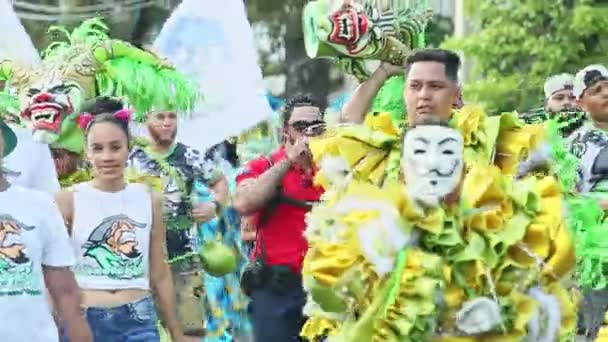Одягнені люди в яскравих карнавальних костюмах ходять по міській вулиці під час фестивалю домікан. — стокове відео