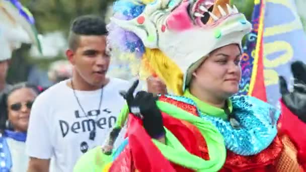 Closeup citizens in varied carnival costumes walk on city street at dominican festival — Stockvideo