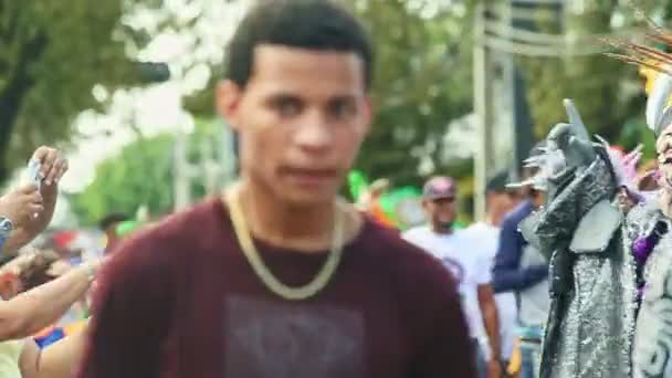 Personas de primer plano en diferentes disfraces de carnaval caminan por la calle de la ciudad en el festival dominicano — Vídeo de stock