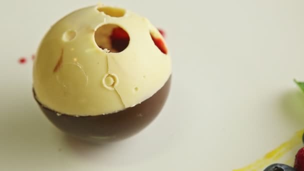 Gros plan finement décoré chocolat en forme de boule dessert tourne sur plaque — Video