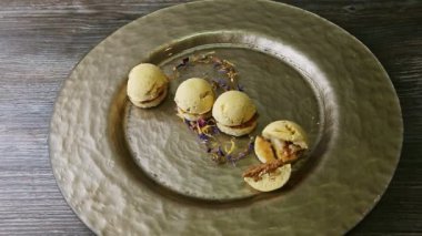 Yarısı yenmiş, dört küresel sünger bisküvisi altın tabakta.