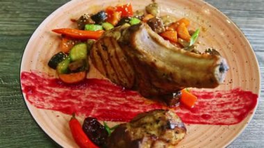 Büyük bir parça et ve pembe tabakta ızgara sebzelerle kavurulmuş kaburgaya yavaşça yakınlaştır.