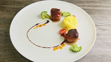 Domuz pastırması, patates püresi ve brokoli ile kızartılmış et parçalarına yakınlaş.