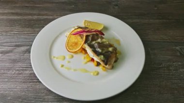 Doldurulmuş deniz balığını çatalla ve bıçakla kesmeye hazır eller.