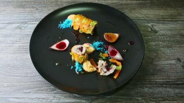 Siyah restoran tabağında yarısı yenmiş sebze dolması.
