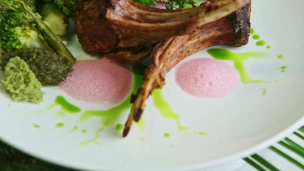 Primer plano panorama abajo en costillas fritas modernamente decoradas con verduras verdes — Vídeo de stock