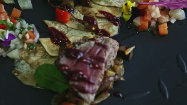 Nahaufnahme Fokus auf mindestens gebratene Fleischstücke mit Kartoffelchips und Gemüsesalat auf schwarz — Stockvideo