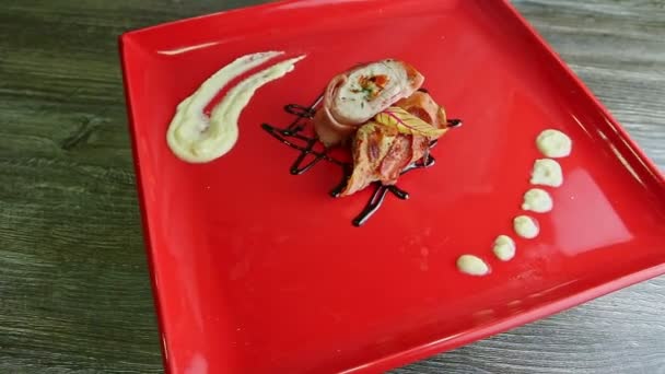Utsökt dekorerad stoppad köttfärslimpa bakad i bacon roterar på röd platta — Stockvideo