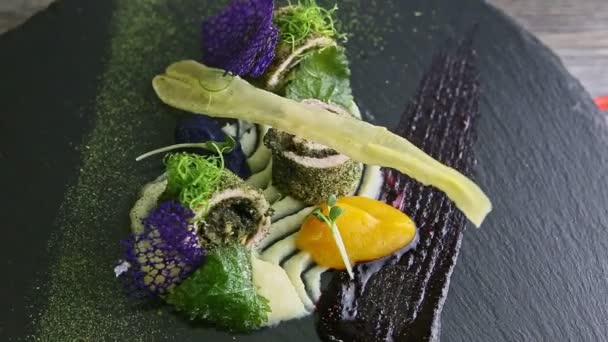 Zoom out from finely decorated fish rolls spinning around on black plate — Stock Video