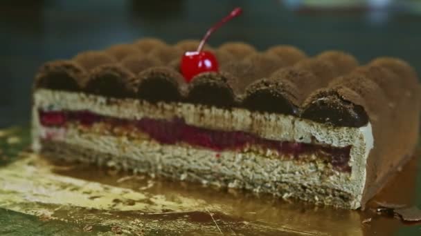 Close-up focus in op de helft van de oorspronkelijke romige chocoladetaart met fruit gelei tussenlaag — Stockvideo