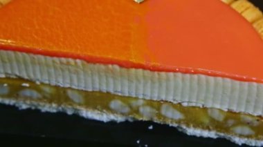 Turuncu ayna jöleli cheesecake 'in yarısına yakın panorama.