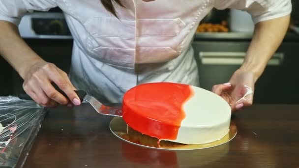 Konditor legt ganzen glasierten runden Käsekuchen auf goldenen Teller — Stockvideo