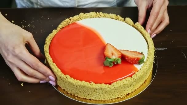 Közelkép cukrász kéz díszíteni a keksz határán kerek sajttorta — Stock videók