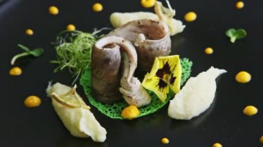 closeup black plate with exquisite decorated fish dish spin around