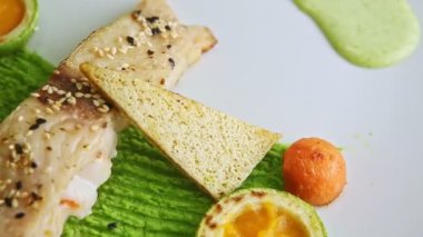 top view closeup plate with fried white fish piece spin around