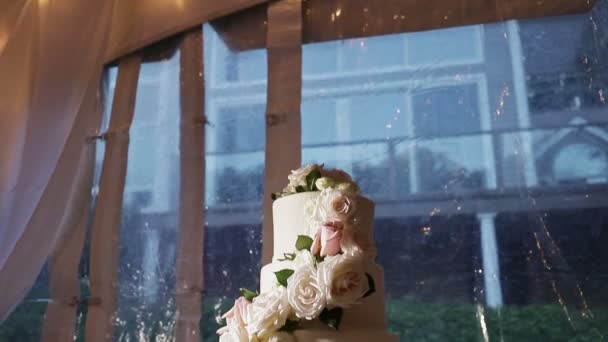 Panorama para baixo no bolo de casamento de quatro camadas com rosas grandes — Vídeo de Stock