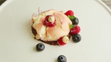 zoom out from broken mousse creamy dessert with berries, mint, and bize