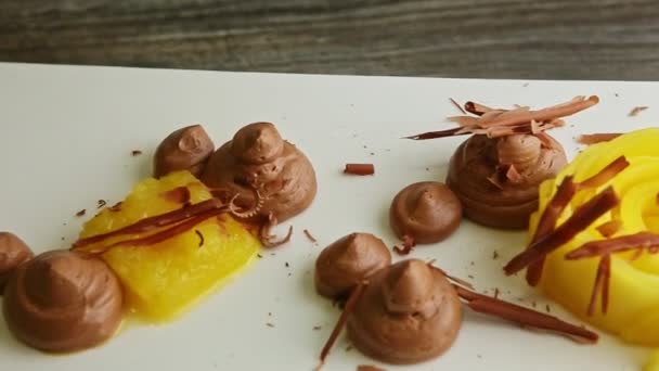 Nahaufnahme fein dekoriertes Dessert aus Früchten und Schokoladenmousse auf Teller — Stockvideo