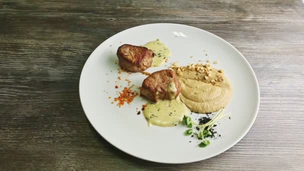 Top view of two tasty pieces of grilled meat with puree and sauce — Stok video