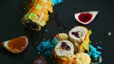 closeup trendy decorated stuffed meat vegetable rolls slowly rotate on black plate
