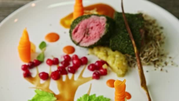 Closeup focus in at finely decorated modern restaurant meat dish with vegetables — Stockvideo