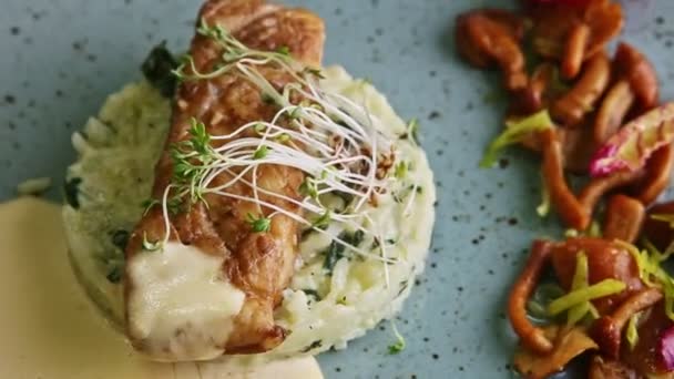 Primo piano sul piatto blu con pesce arrosto di mare e guarnire gira intorno — Video Stock