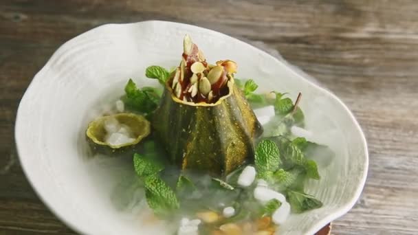 Zoom lento en el postre de calabaza decorado con humo blanco gira en plato blanco — Vídeos de Stock