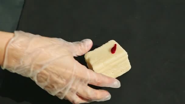 Вид зверху на жіночі руки замішують великий шматок білого марципана з помаранчевим барвником — стокове відео