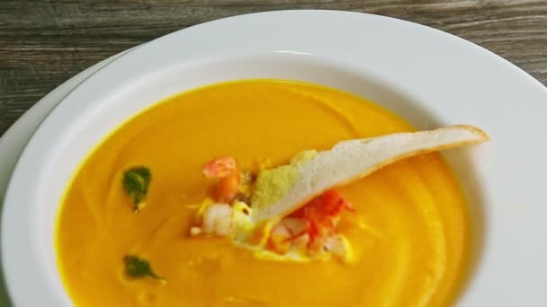 Panorama de primer plano en sopa de crema de pescado decorado y colas de langostinos en tazón — Vídeos de Stock