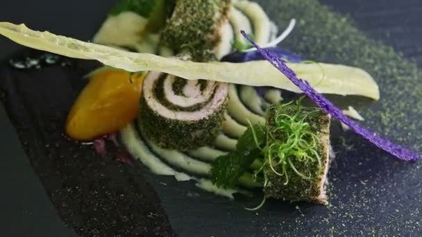 Closeup finely decorated fish rolls with sauces spinning on black plate — Stock Video