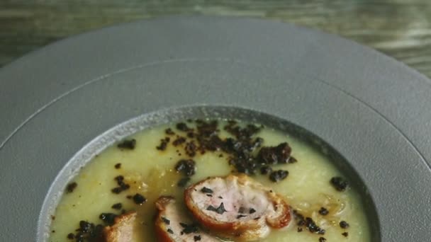 Панорама крупным планом на суп с луковым кремом, украшенный домашними ломтиками колбасы — стоковое видео